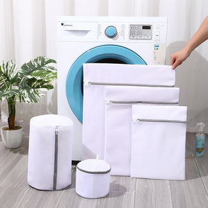 Mesh laundry bags in front of a washing machine