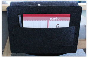 Dark grey felt bedside caddy holding a notebook and pen