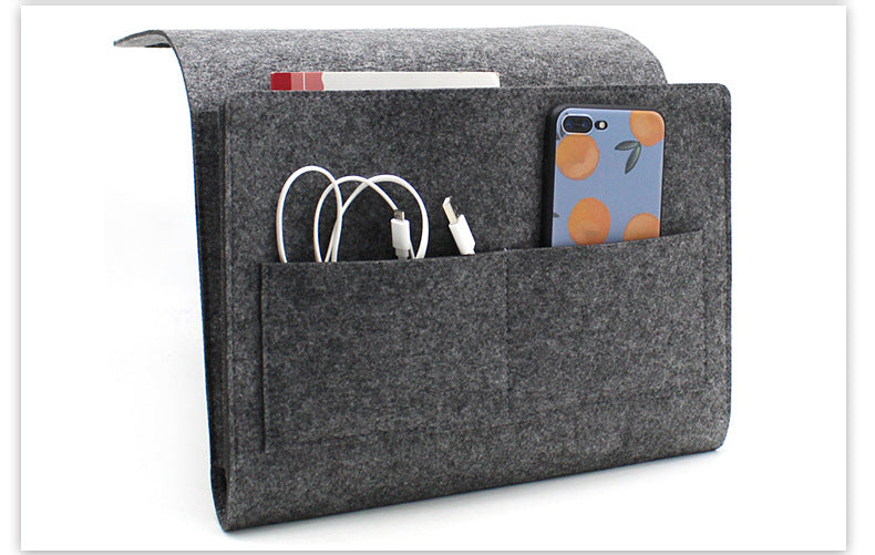 Grey felt bedside caddy holding a phone and cables