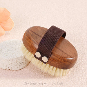 Wooden body brush with boar bristles next to a pumice stone — dry brushing with pig hair