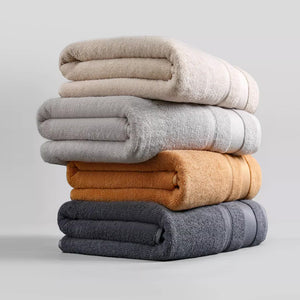 Stack of folded cotton bath towels in four colours