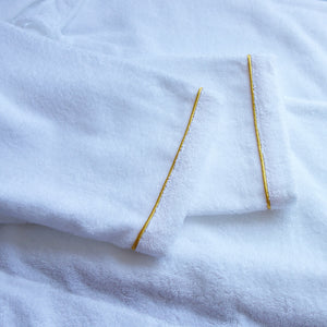 Close-up of bathrobe sleeve cuff with gold piping