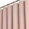 Fabric shower curtain hanging from a rail with metal eyelets and rings