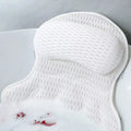 White mesh bath pillow resting against a bathtub