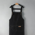 Black canvas kitchen apron on a hanger