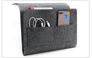 Grey felt bedside caddy holding a phone and cables