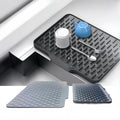 Grey silicone dish drying mat beside a sink with cups and cutlery